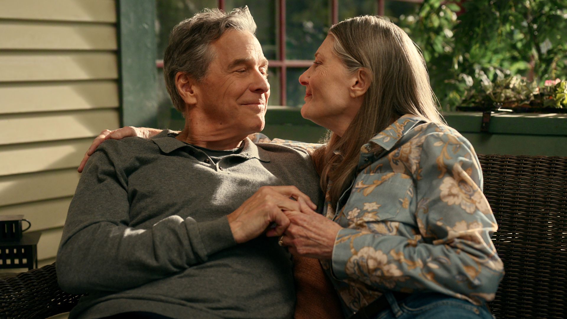 Doc and Hope embrace each other on their front porch bench