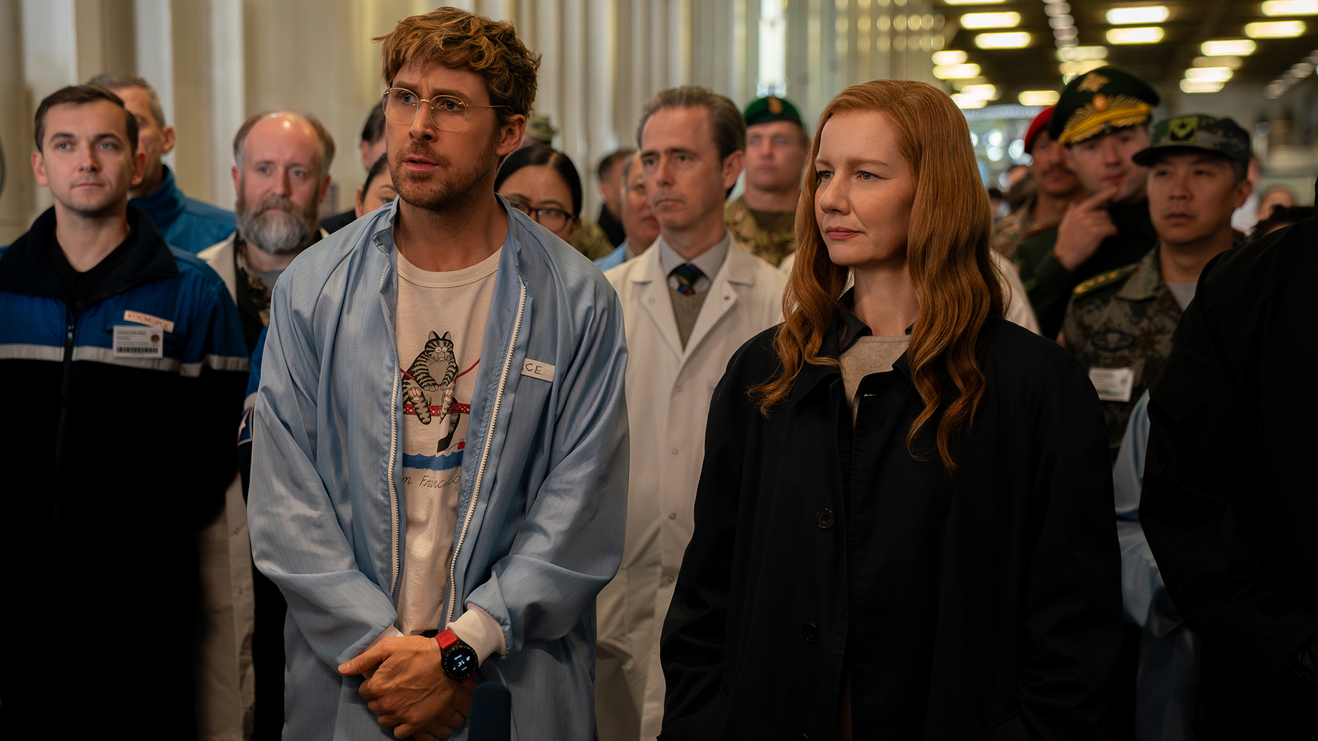 Ryland Grace and Eva Stratt watch an experiment with a group of people in Project Hail Mary