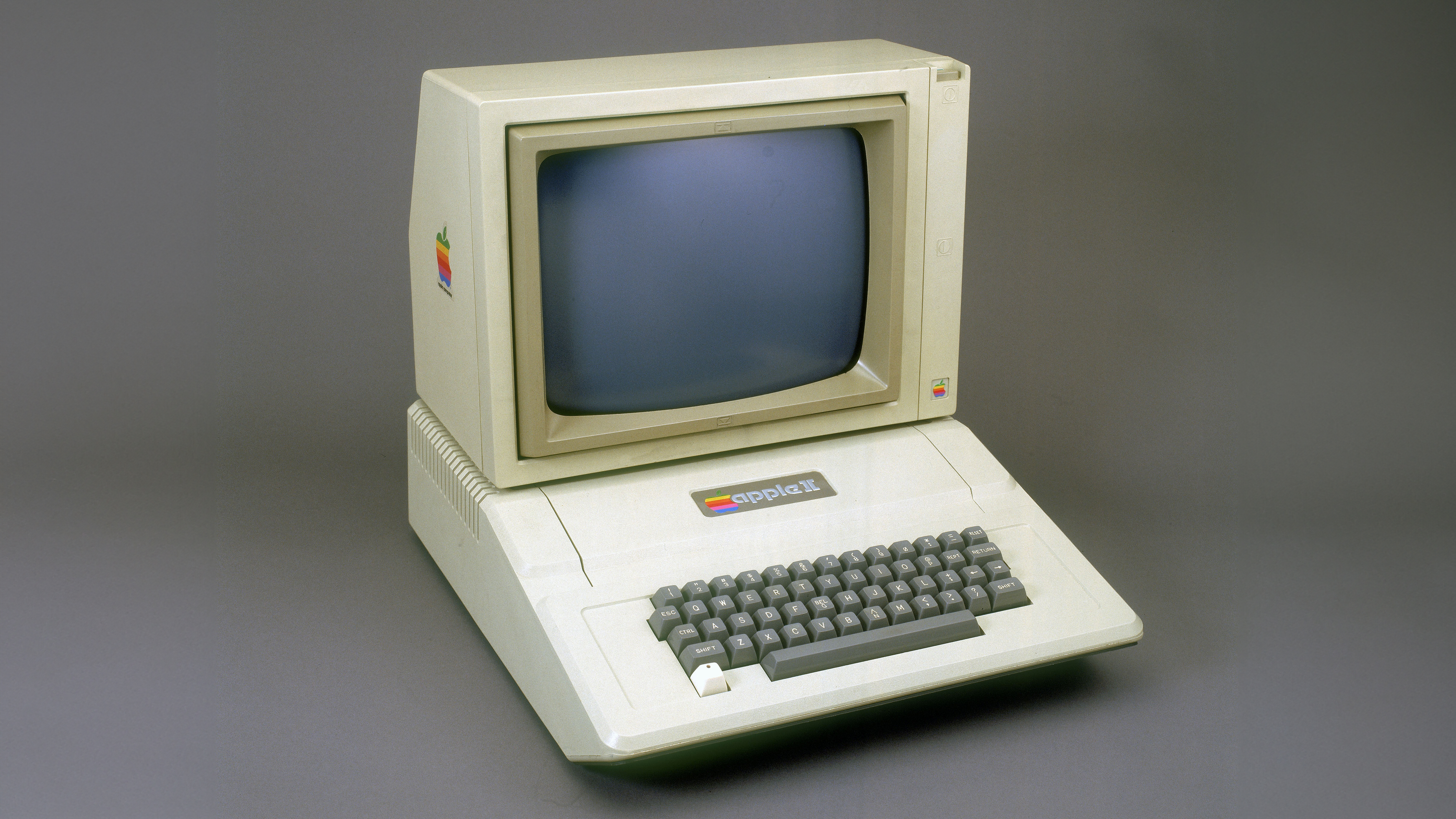 The Apple II computer sits on a gray backdrop