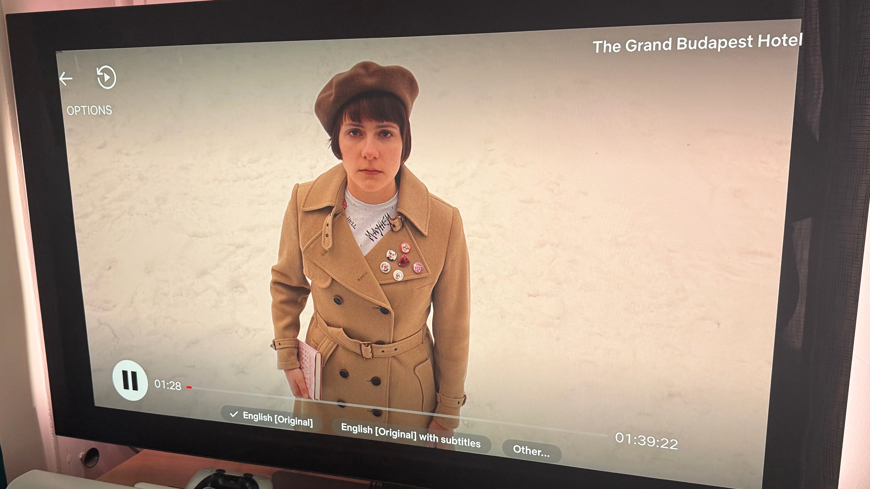 An image from The Grand Budapest Hotel showing a character on snowy ground. The new Netflix interface is superimposed over the image