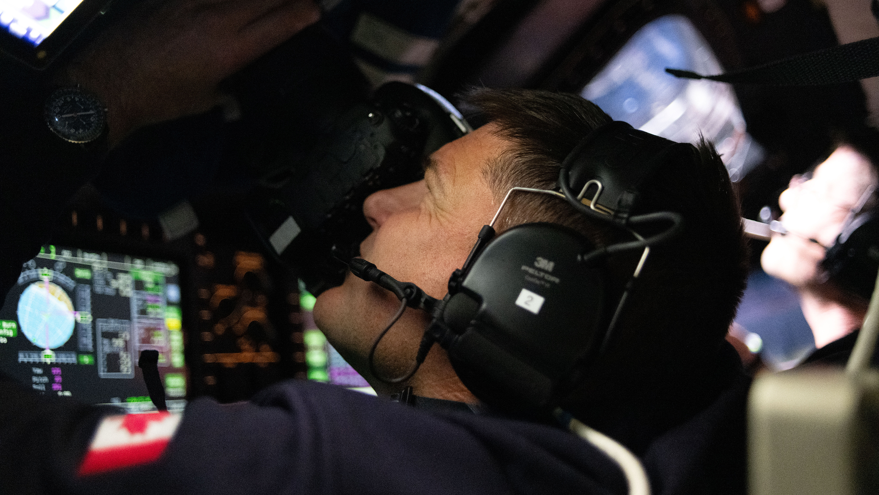 An Artemis II astronaut taking pictures through the craft's window