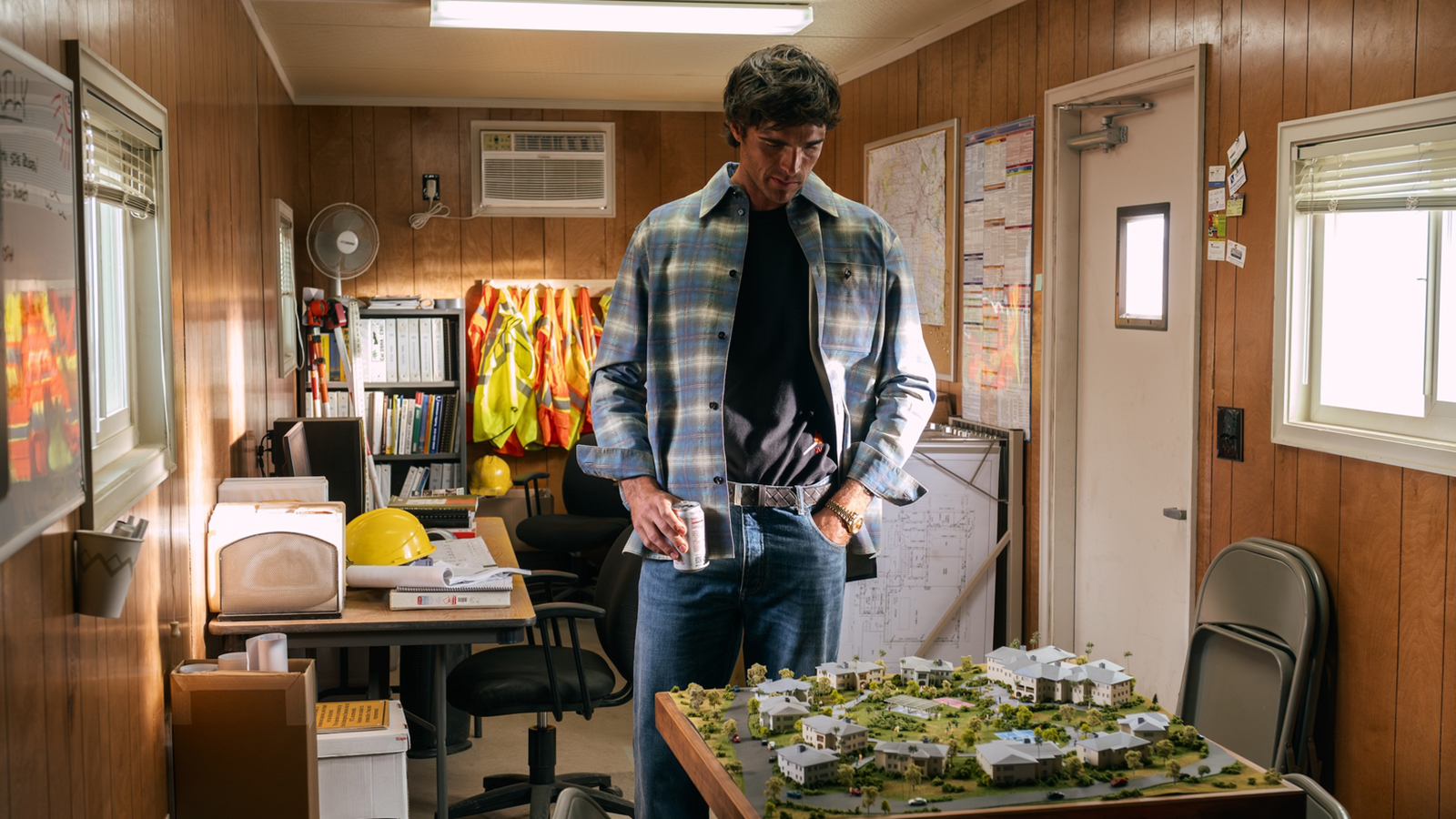 Nate looks down at a scale model while holding a cup in Euphoria Season 3