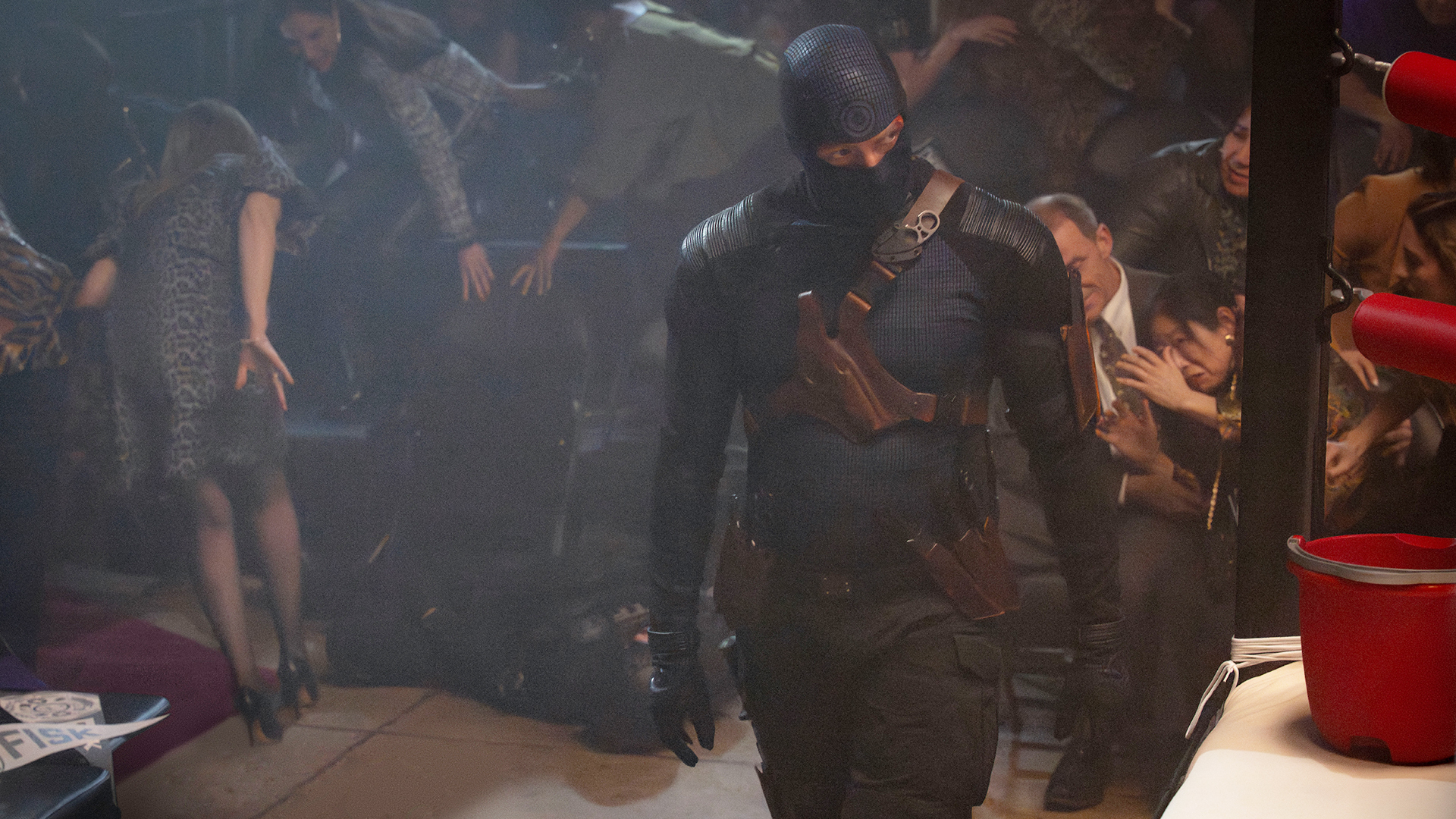 Bullseye walks next to a boxing ring as people flee behind him in Daredevil: Born Again Season 2 Episode 5