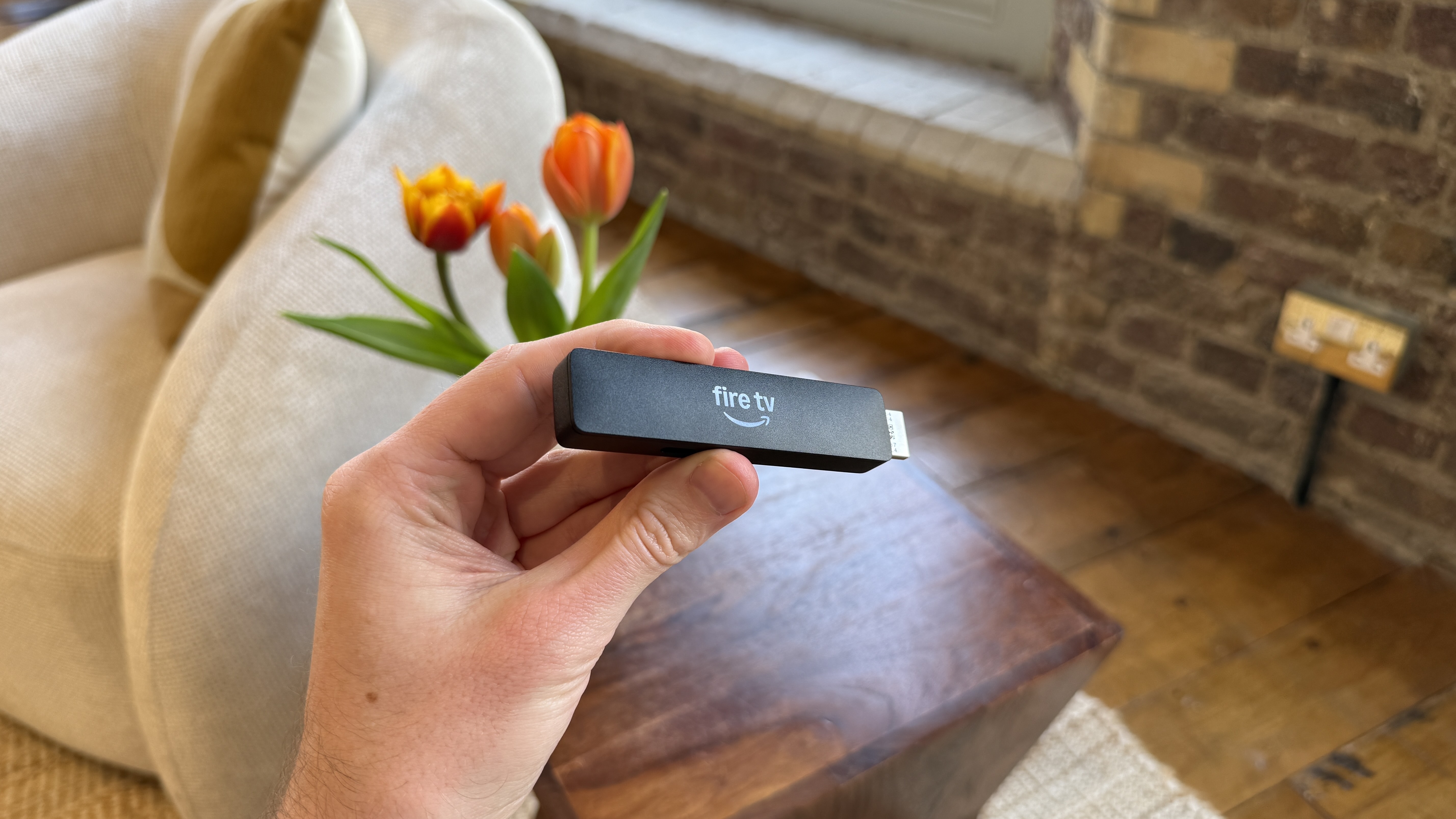 Amazon Fire TV Stick HD is held in a person's hand