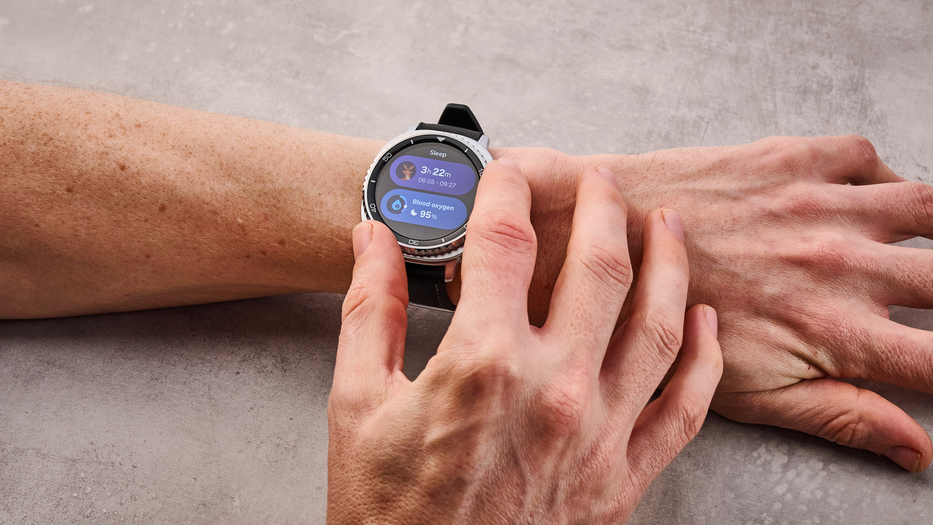 Samsung Galaxy Watch 8 Classic on a man's wrist; he turns its dial to select its sleep functions.
