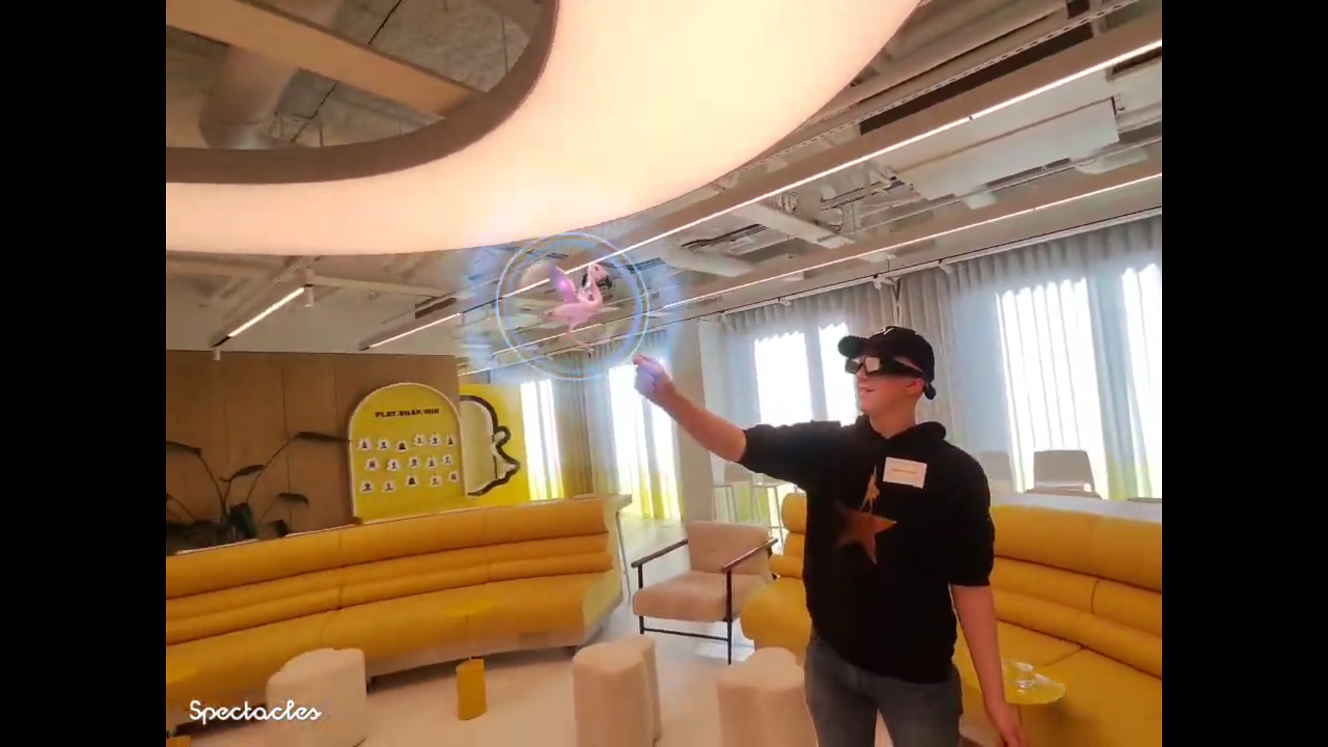 Hamish wearing the Snap glasses plays with an AR flamingo