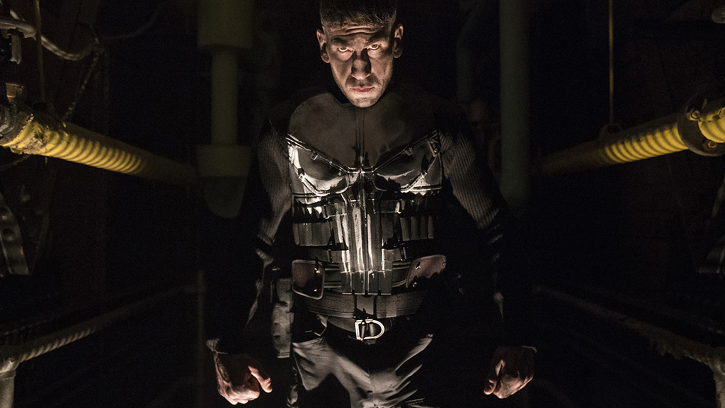 Jon Bernthal's Punisher emerges from the shadows wearing the comic book character's iconic costume, complete with spray-painted skull on the front