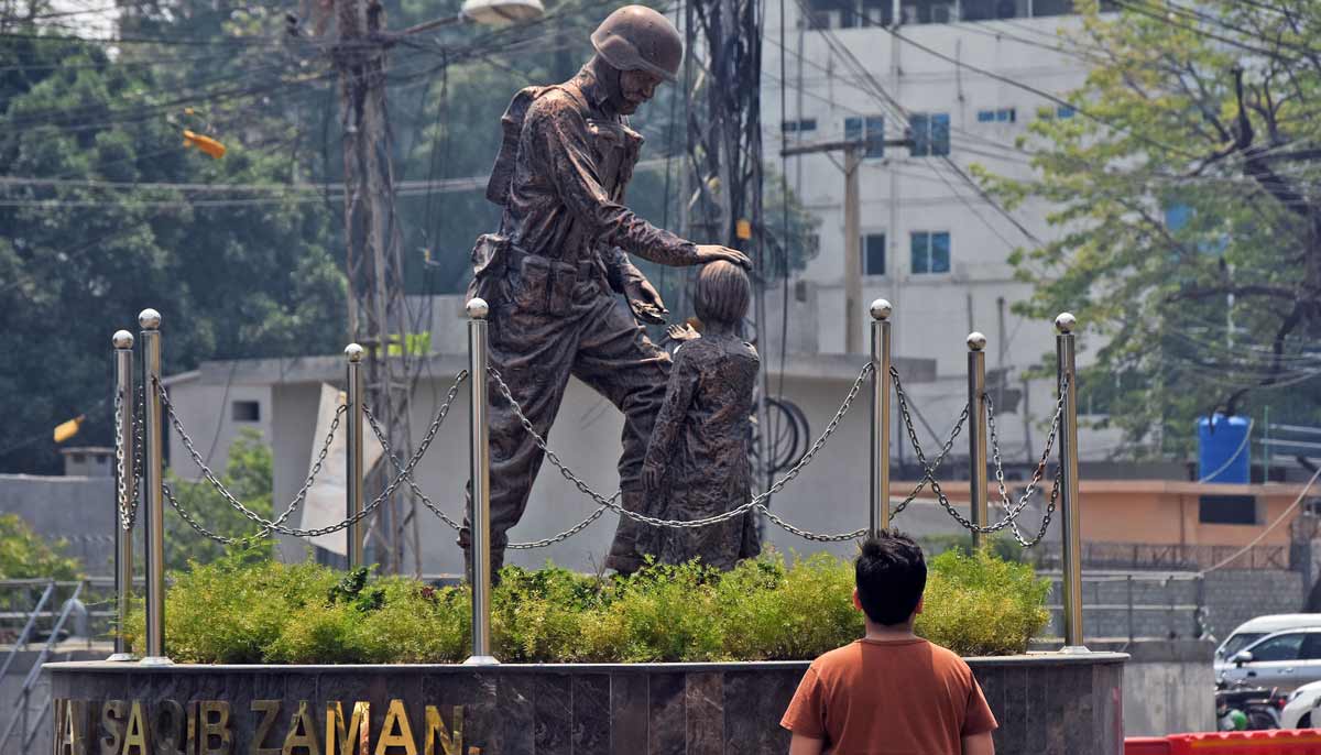A young boy looks like an army soldier sculpture displayed around the Panj Sarki area of ​​the city as Pakistan commemorates the one year anniversary of Operation Bunyan-un-Marsoos. - Online
