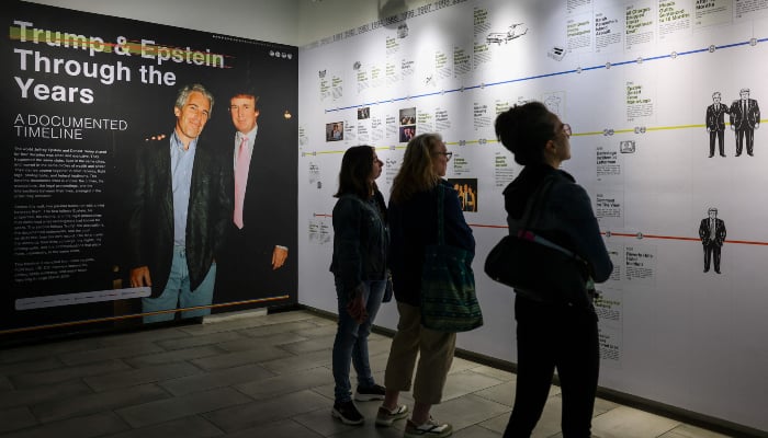 Visitors look at a timeline of events in the Donald J Trump and Jeffrey Epstein Memorial Reading Room, a tribute to the survivors and victims of Epstein's crimes, where 3.5 million pages, 3,437 bound volumes of the Epstein files are displayed in New York City on May 11, 2026. — AFP