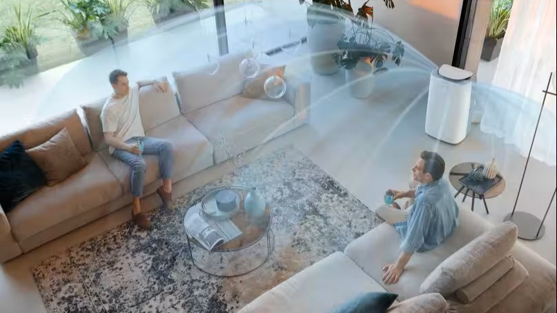 De'Longhi air conditioner in room with two people and lines representing the movement of air