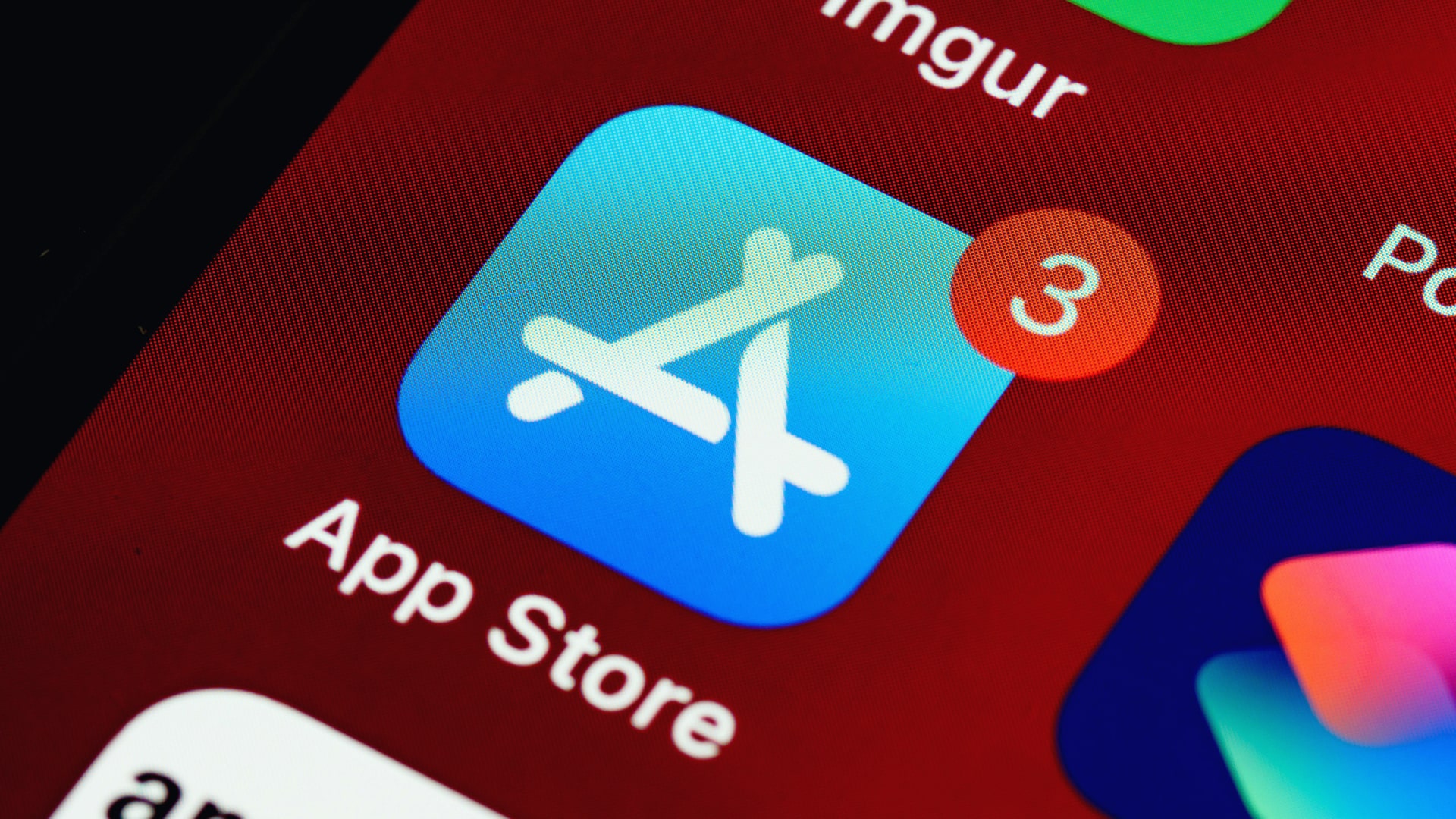 A close-up of an iPhone with the App Store icon prominently in the center of the image.