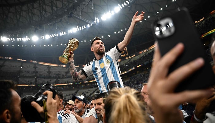 Argentina captain and forward #10 Lionel Messi (R) holds the Fifa World Cup Trophy after the trophy ceremony after Argentina won the Qatar 2022 World Cup final during the soccer match between Argentina and France at the Lusail Stadium in Lusail, north of Doha on December 18, 2022. — AFP
