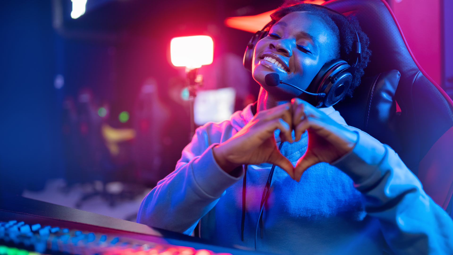 Happy pc gamer showing heart sign with hands