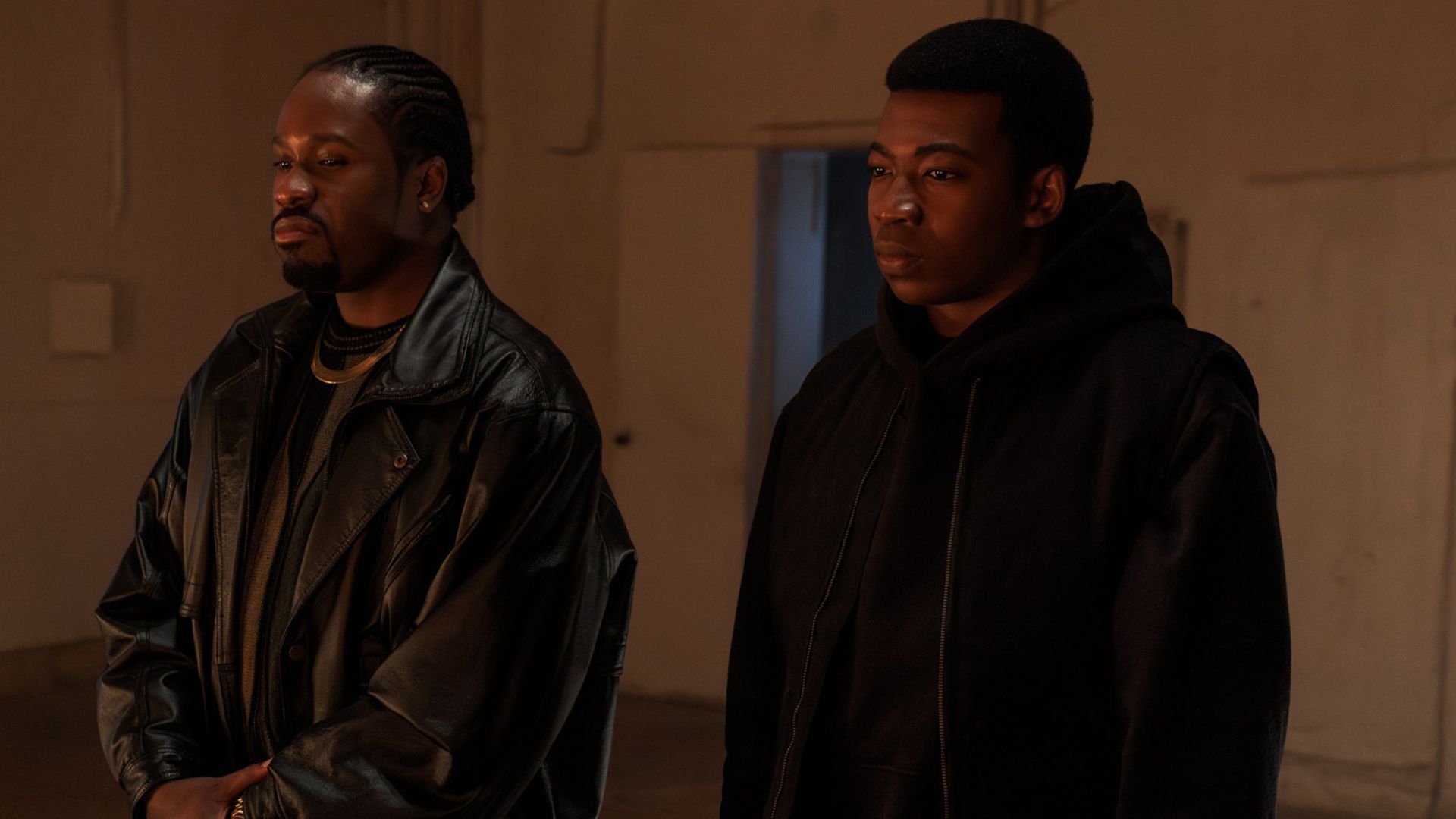Two men look at something off screen