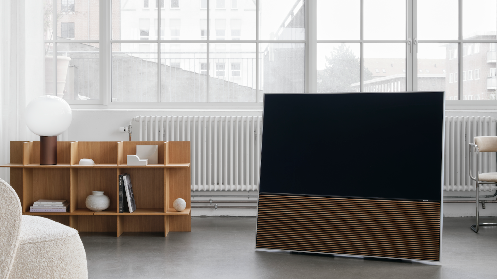 Canvas L soundbar attached to a TV in a brightly lit and neutrally decorated room in front of large windows