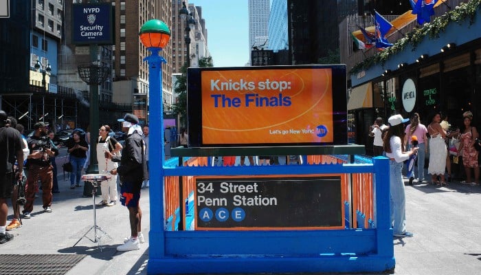 People walk past a New York Knicks-themed 34th Street Penn Station subway entrance on June 4, 2026 in New York City. — AFP
