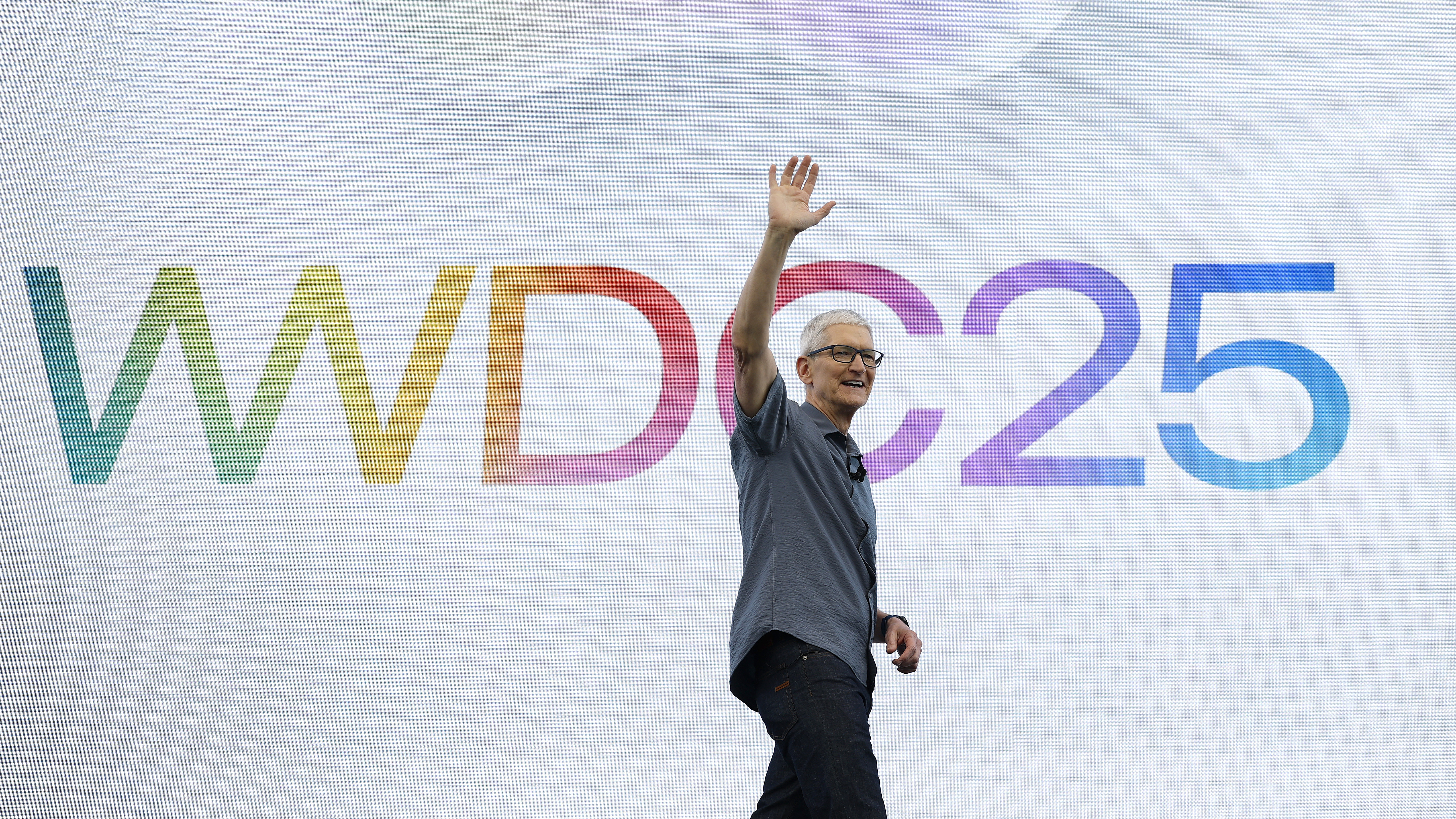 Tim Cook waves on stage at WWDC 2025