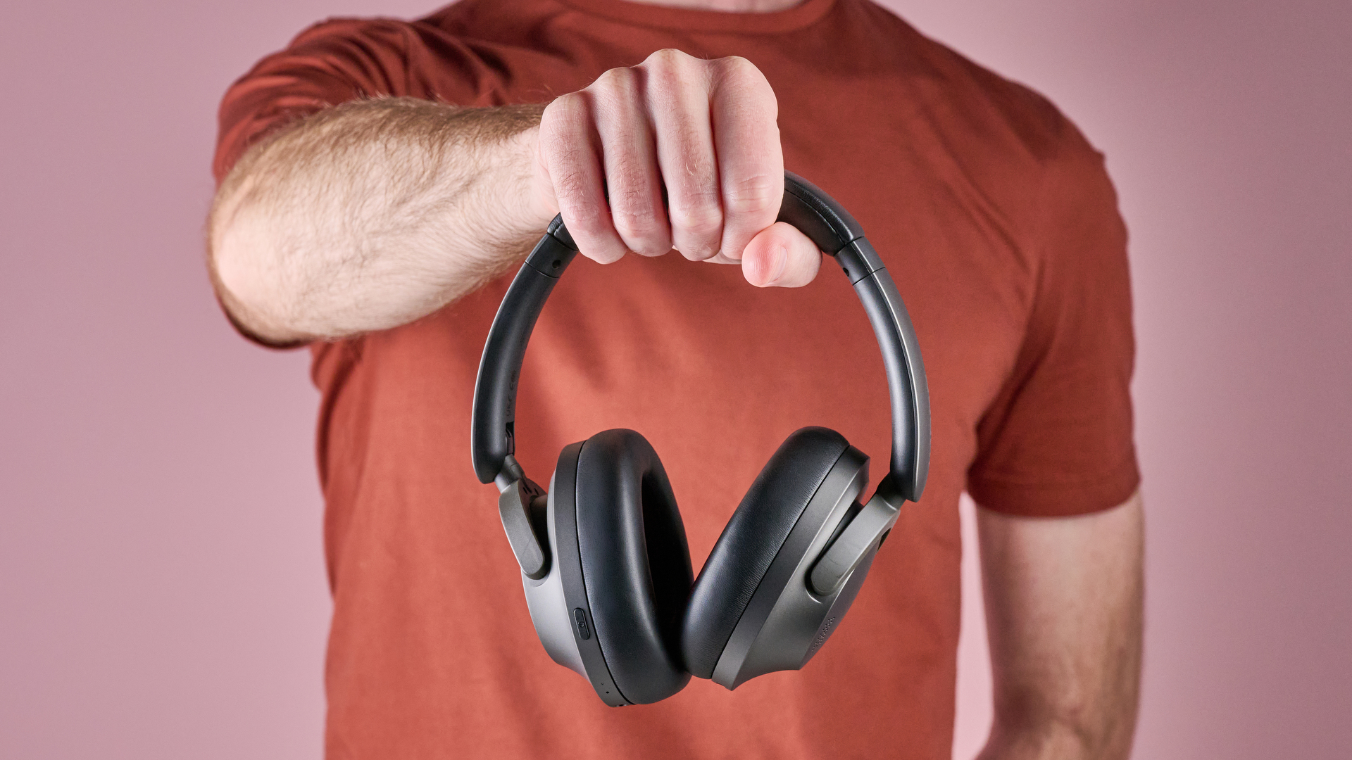 1Several SonoFlow Pro HQ51 headphones held in a man's hands