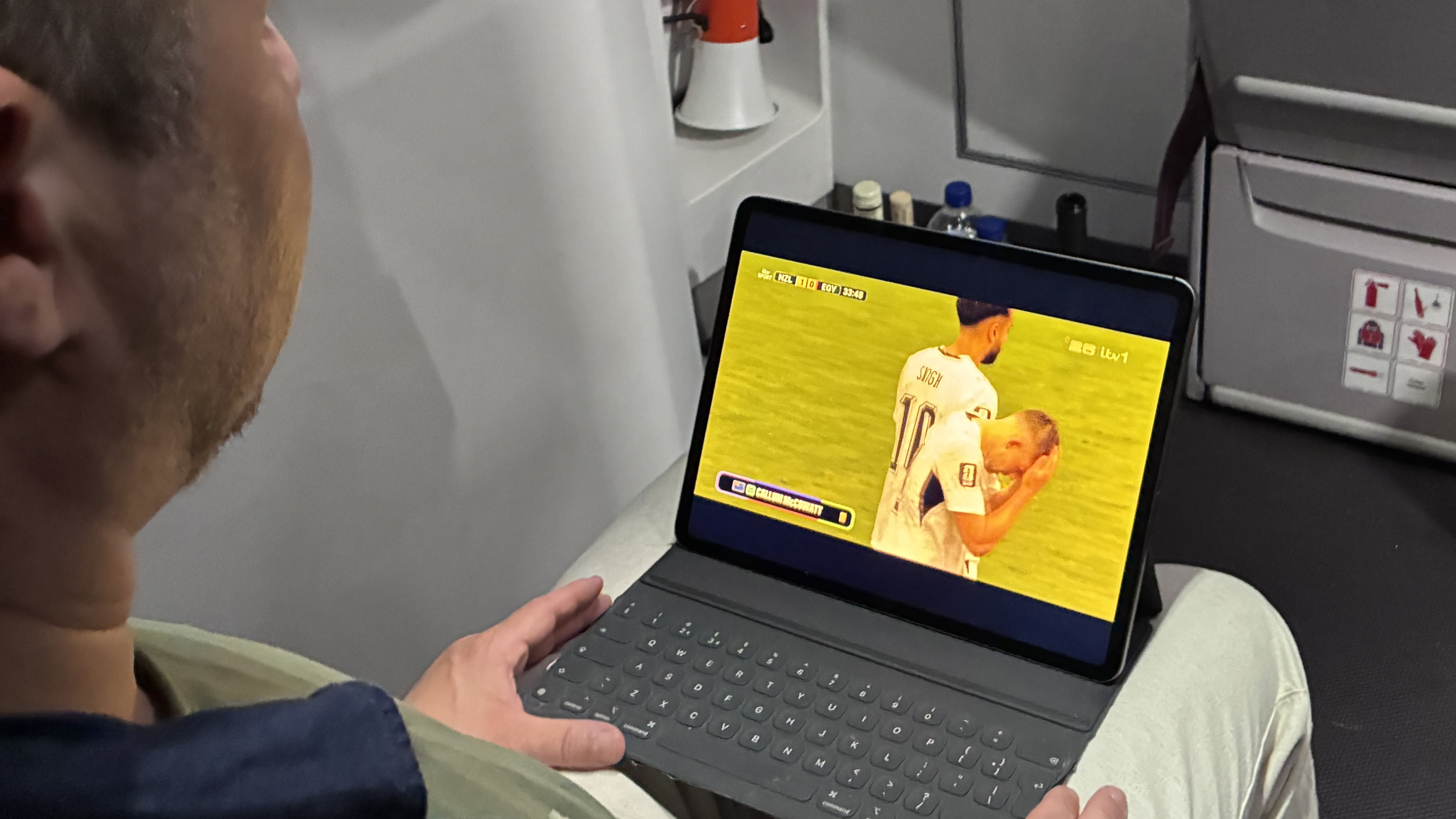 A man watching the World Cup on a Virgin Atlantic flight using Starlink