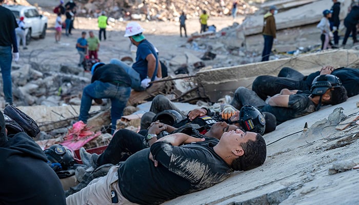 Rescue workers and volunteers rest on the rubble of collapsed buildings in Caraballeda, La Guaira state, Venezuela, on June 28, 2026, after an earthquake. — AFP