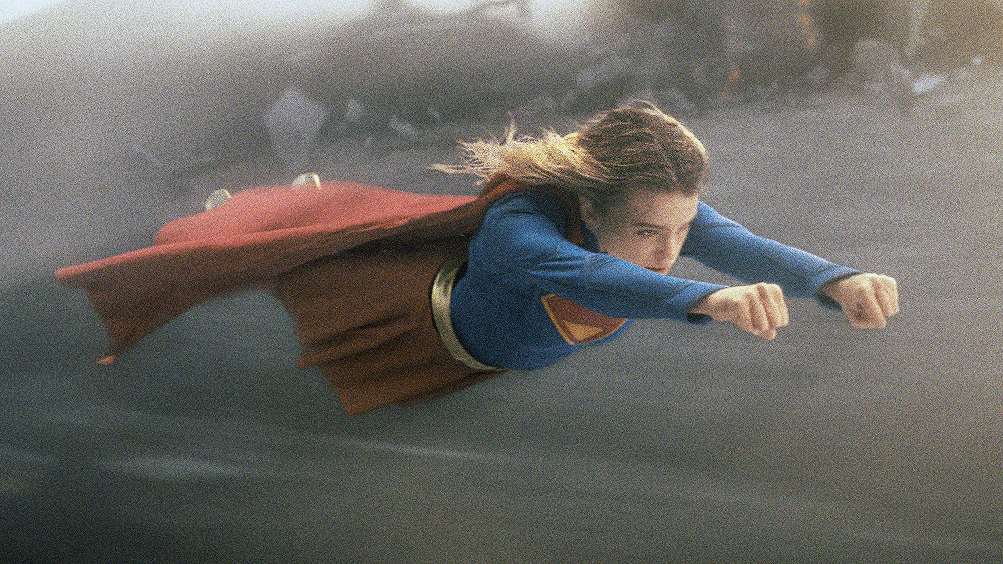 Milly Alcock's Kara Zor-El wearing her classic superhero outfit as she flies through the air in the 2026 Supergirl movie