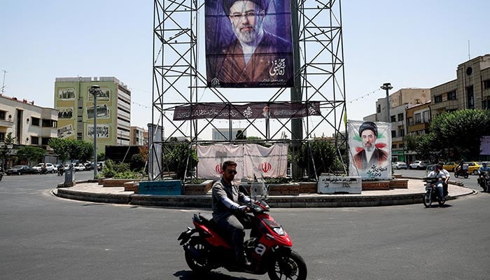 People drive past a banner with a picture of Iran's Supreme Leader, Mojtaba Khamenei, in Tehran, Iran, June 28, 2026. — Reuters
