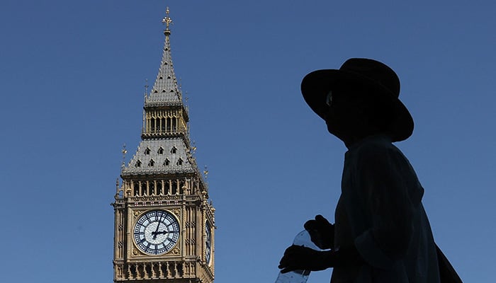 A person holds a water bottle as he walks near Big Ben and the Houses of Parliament, in London, Britain, June 23, 2026. — Reuters