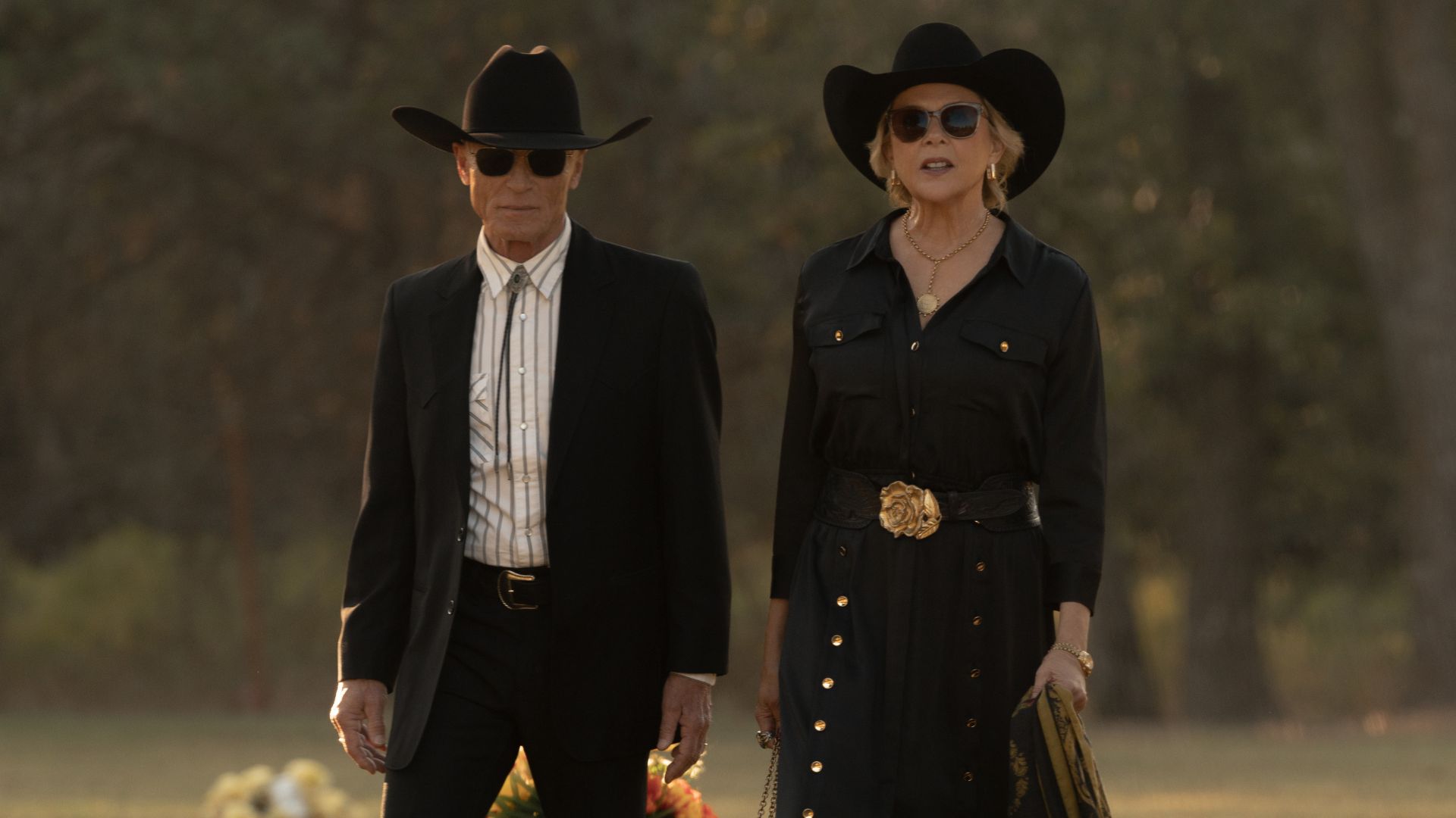 Everett and Beulah walk through a cemetery in funeral garb