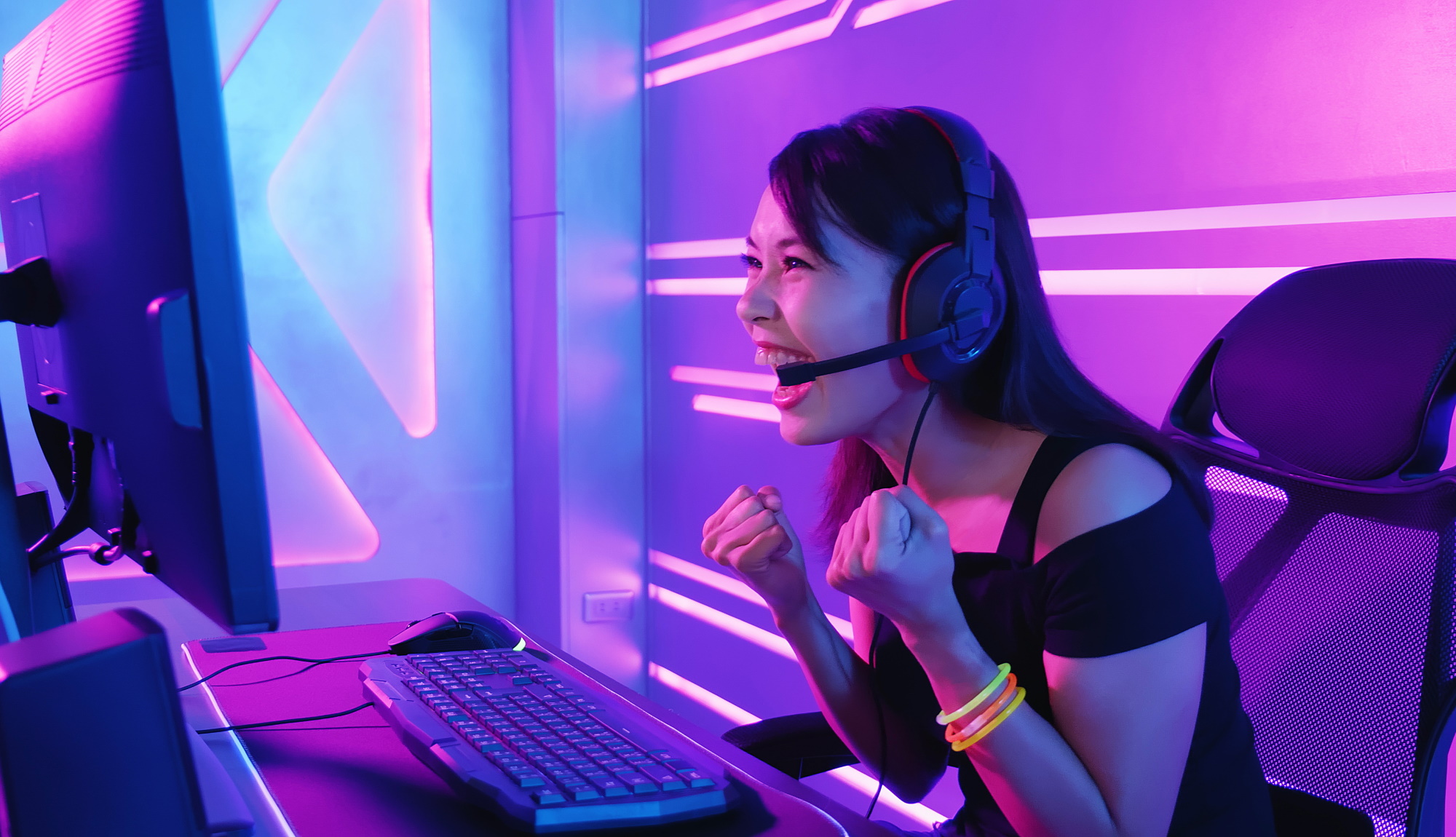 Person at a PC looking happy wearing headphones