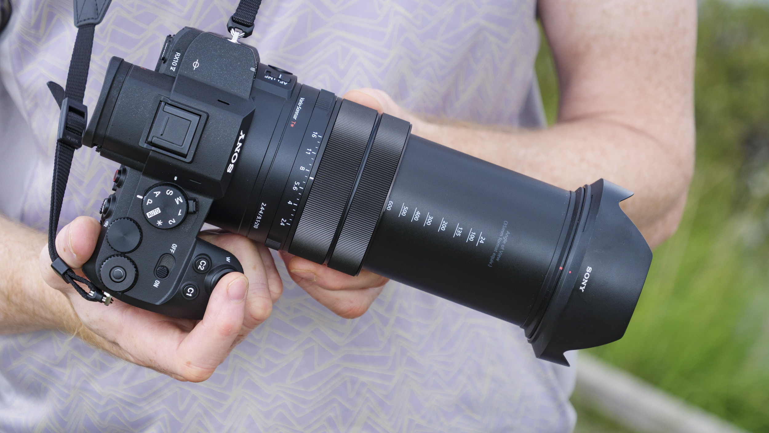Photographer and tech journalist Tim Coleman holds the Sony RX10 V bridge camera, its lens zoomed out