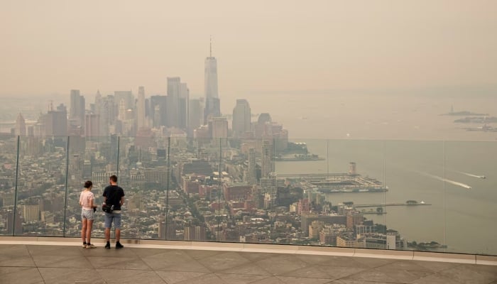 People visit the Edge observation deck as the New York City skyline and One World Trade Center are seen through a blanket of wildfire smoke in New York City, U.S., July 16, 2026. — Reuters