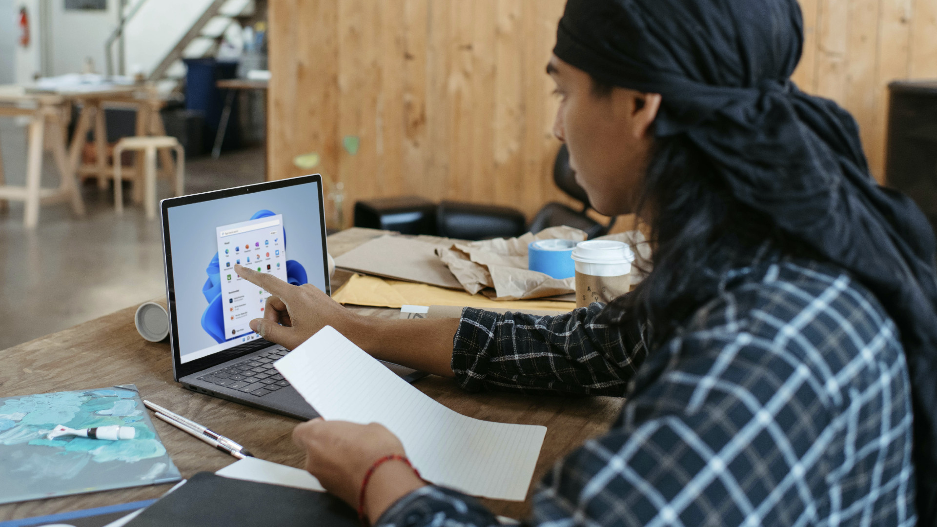 A person using a touch screen with Windows 11 laptop.