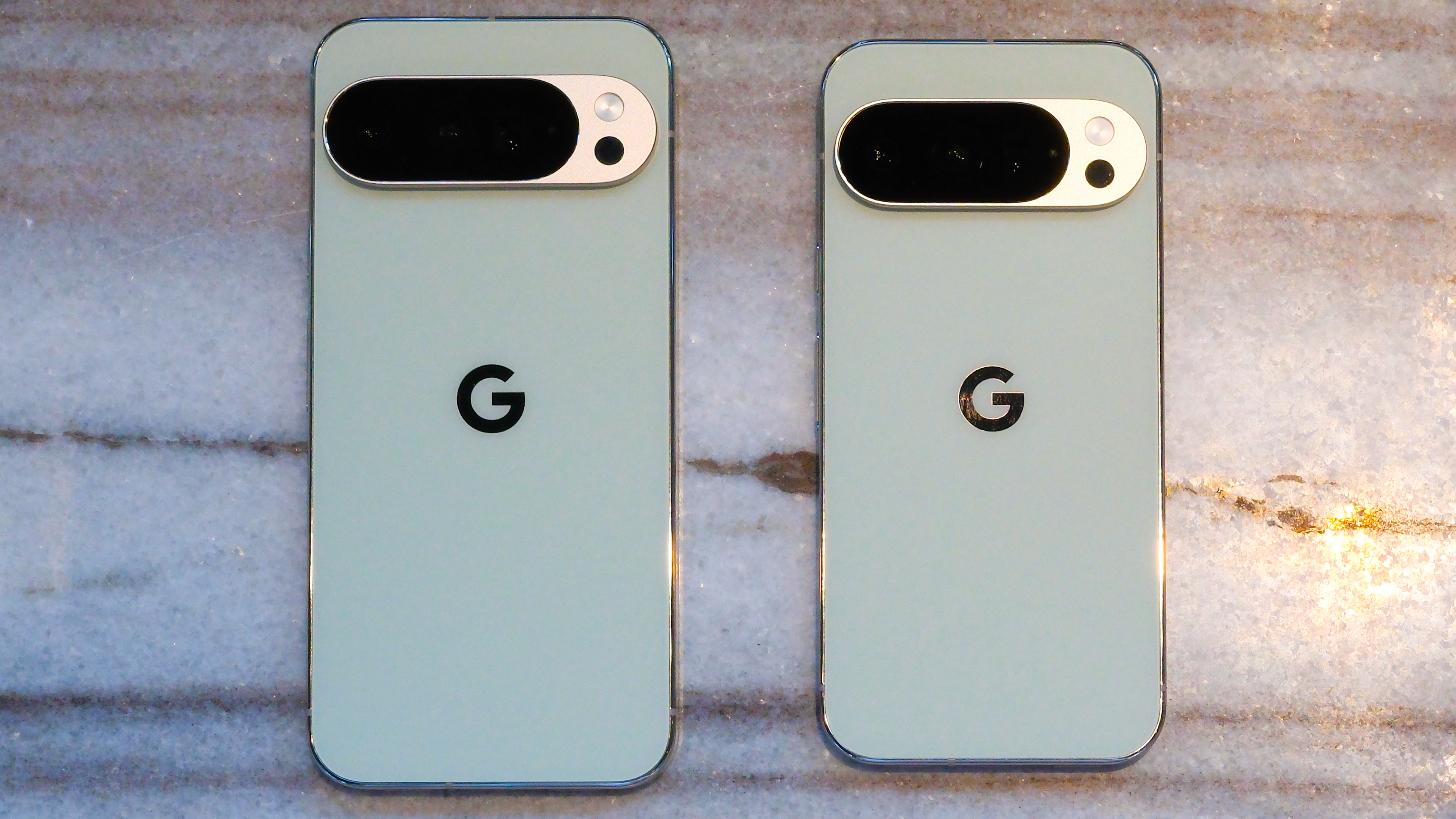 Google Pixel 10 Pro XL in porcelain against a blue background with a green neon Android figure in the background
