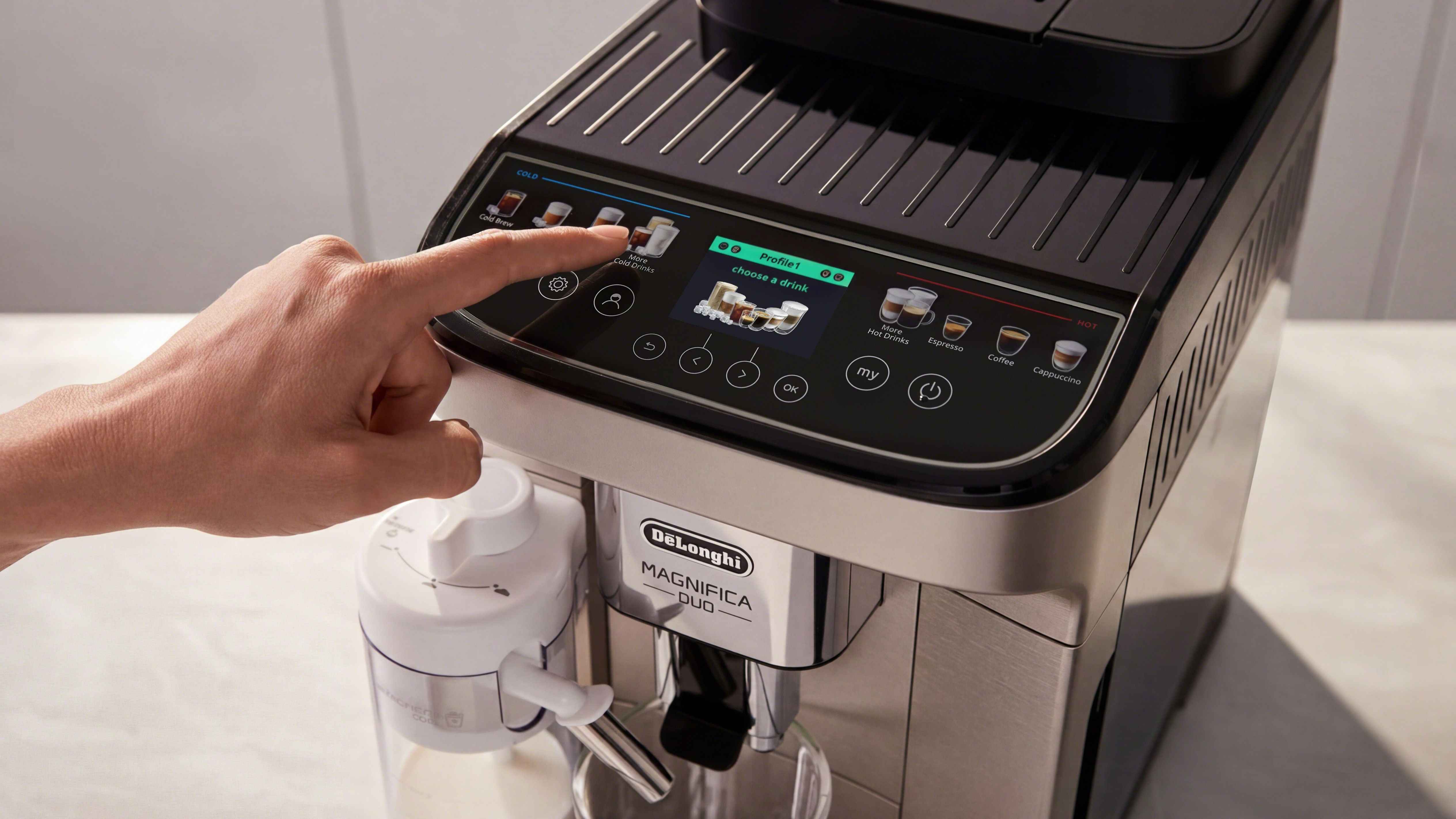 Person pressing button on De'Longhi Magnifica Duo coffee machine